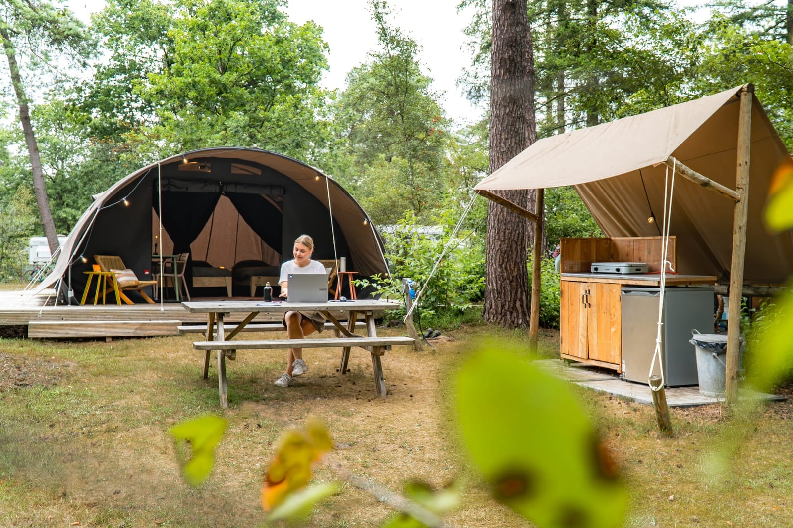 Marketeer van UPPER aan het werk op een camping tussen de tenten